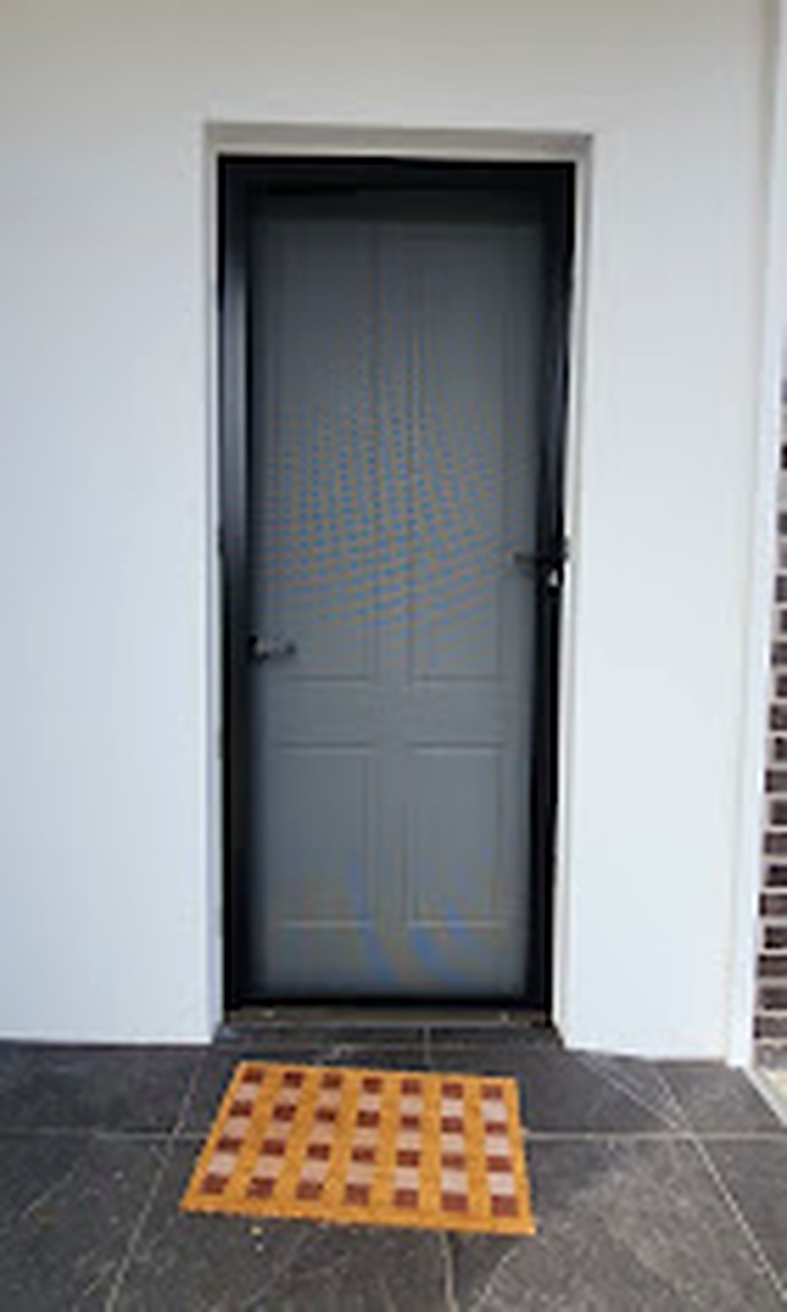 Dark security screen door installed at a modern entry