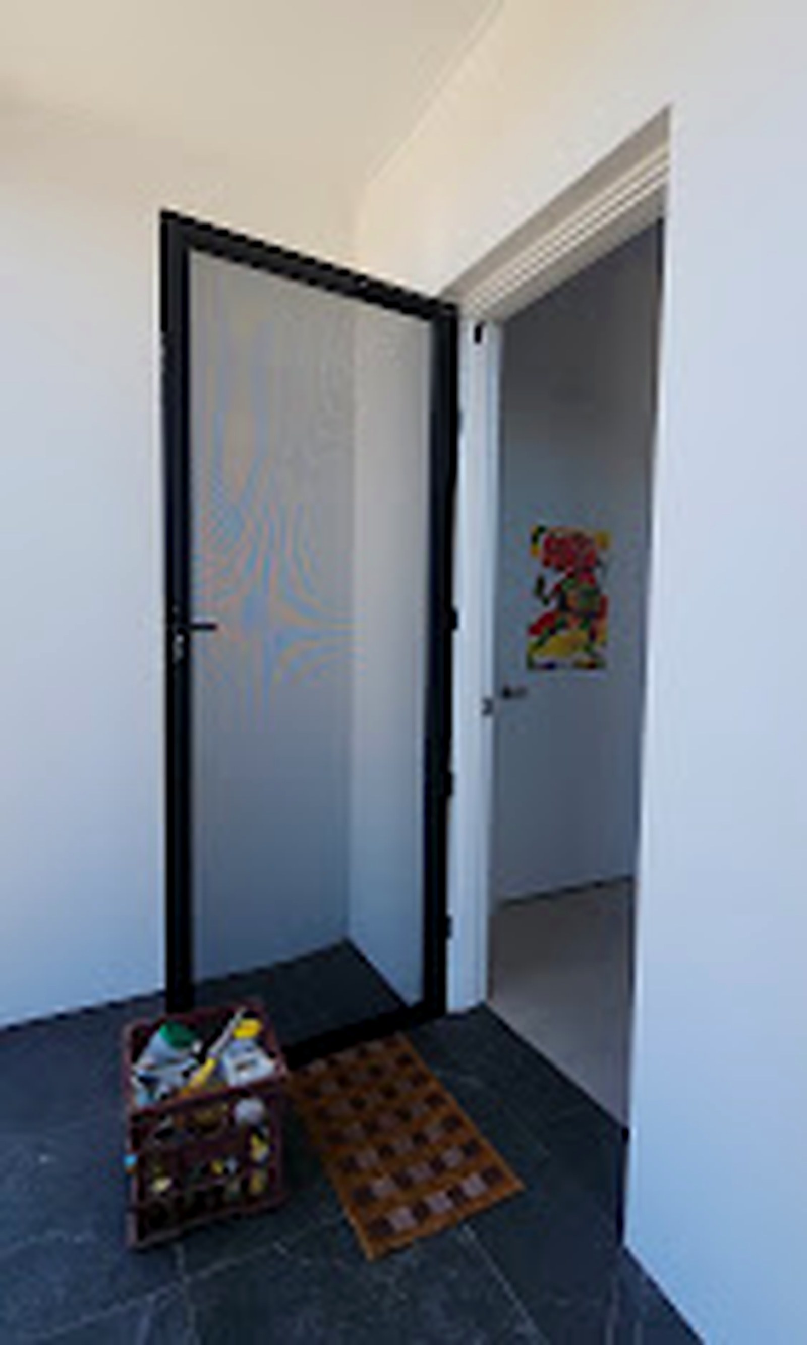 Hinged screen door open at a residential entry